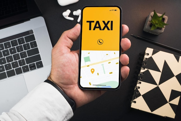 Uomo che tiene uno smartphone con l'app Taxi Service su sfondo nero. Ambiente d'ufficio. Fornitore di servizi di mobilità in tutto il mondo.