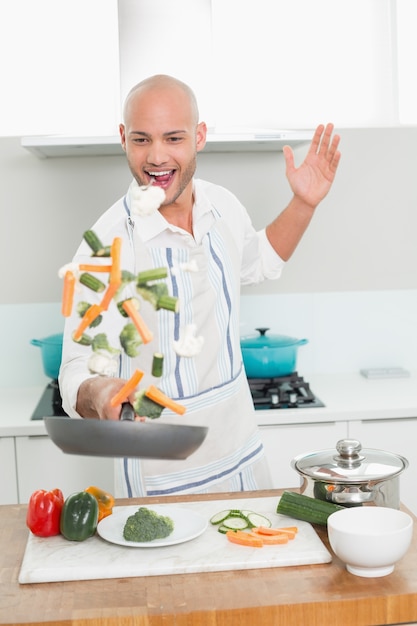 Uomo che tira le verdure in cucina