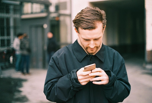 Uomo che usa il cellulare in città