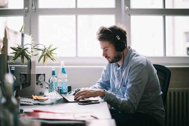 Uomo che usa il portatile sul tavolo in ufficio