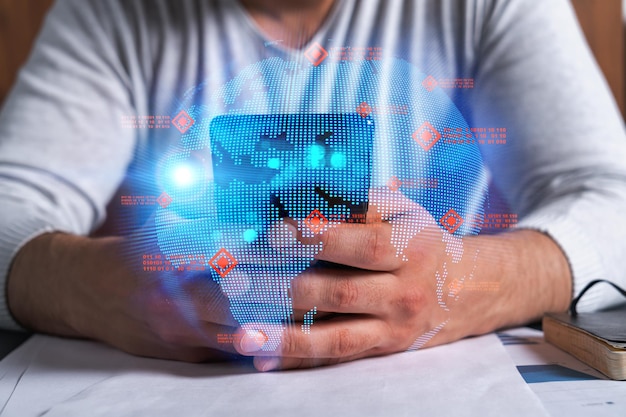 Uomo che usa il telefono Mani che digitano lo smartphone Doppia esposizione con l'ologramma del pianeta terra della mappa del mondo Primo piano concetto di connessione Internet e persone