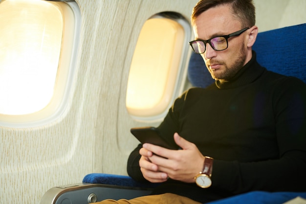 Uomo che usando smartphone in volo