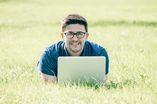 Uomo che utilizza computer portatile nel parco della città