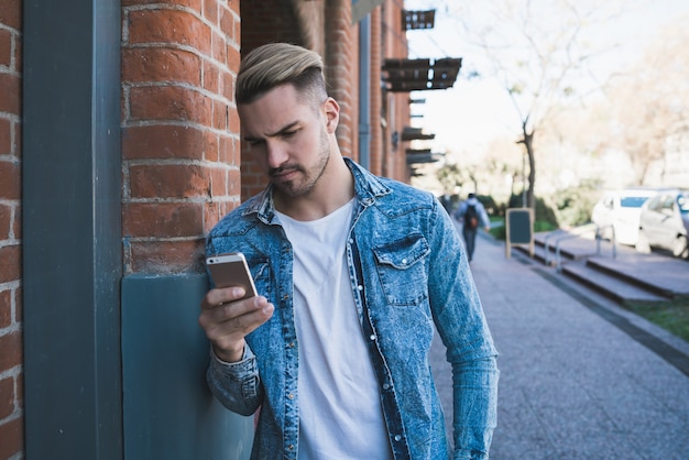 Uomo che utilizza il suo telefono cellulare.