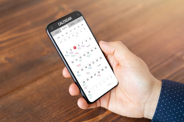 Uomo che utilizza l'app del calendario sul telefono cellulare