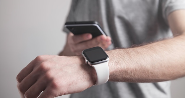 Uomo che utilizza smart watch e smartphone