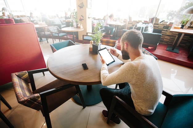 Uomo che utilizza tablet pc con una matita alla scrivania