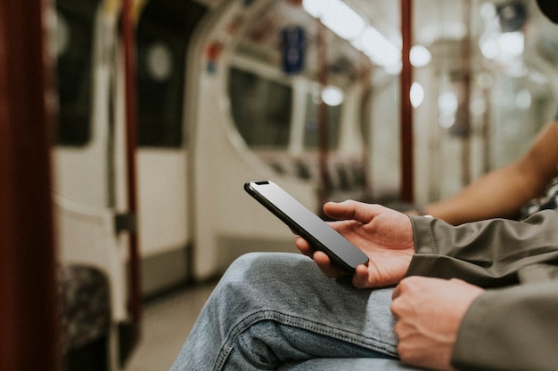 Uomo che utilizza uno smartphone su un treno