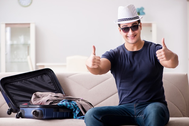 Uomo che va in vacanza imballando la sua valigia