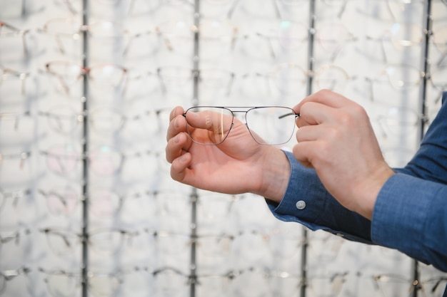 Uomo che valuta la qualità degli occhiali nel negozio di ottica