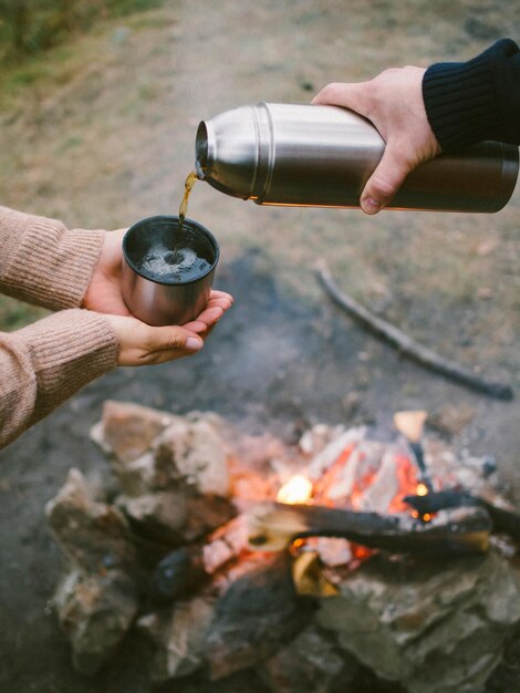 uomo che versa il tè da un thermos