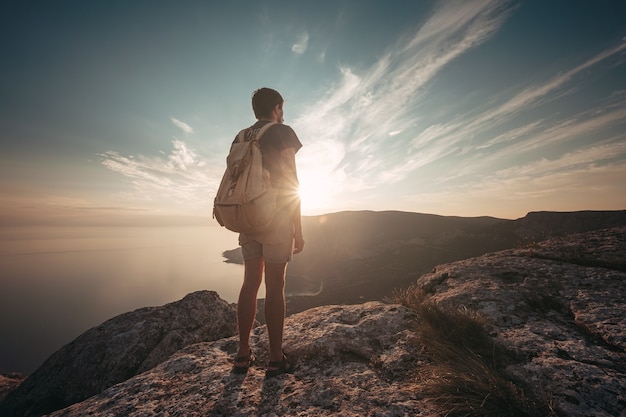 Uomo che viaggia con lo zaino che fa un'escursione in montagna. Viaggi Lifestyle concetto di successo avventura vacanze attive sport alpinismo all'aperto, abbigliamento hipster