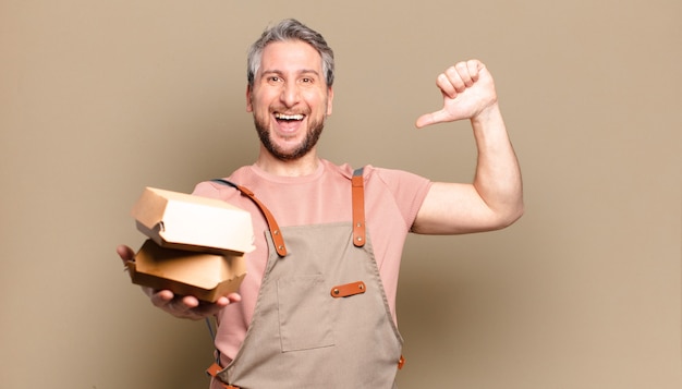 Uomo chef di mezza età con hamburger. concetto di barbecue