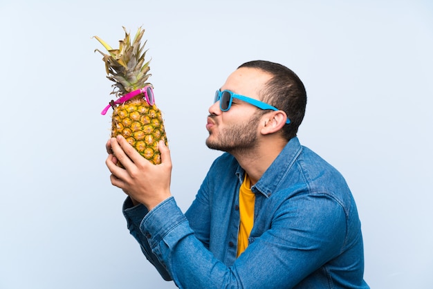 Uomo colombiano che tiene un ananas con occhiali da sole