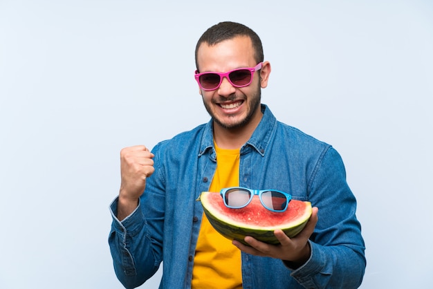 Uomo colombiano che tiene un'anguria con occhiali da sole