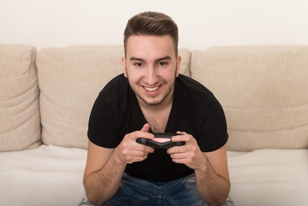 Uomo competitivo che gioca ai videogiochi ed eccitato felice allegro a casa