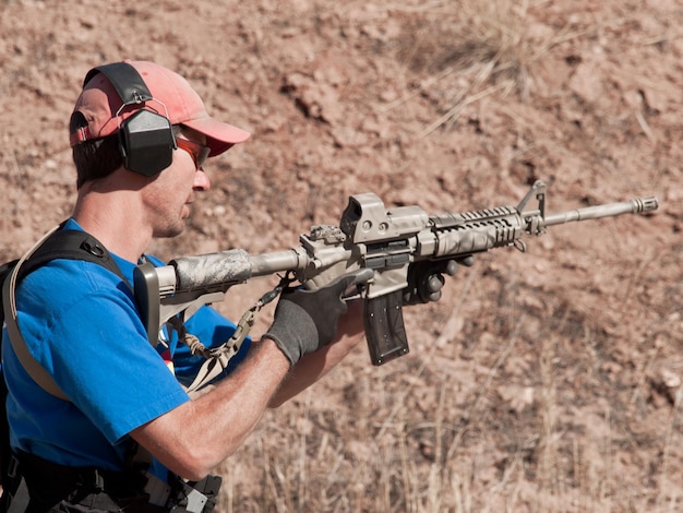 Uomo con AR-15 che pratica tiro al bersaglio.