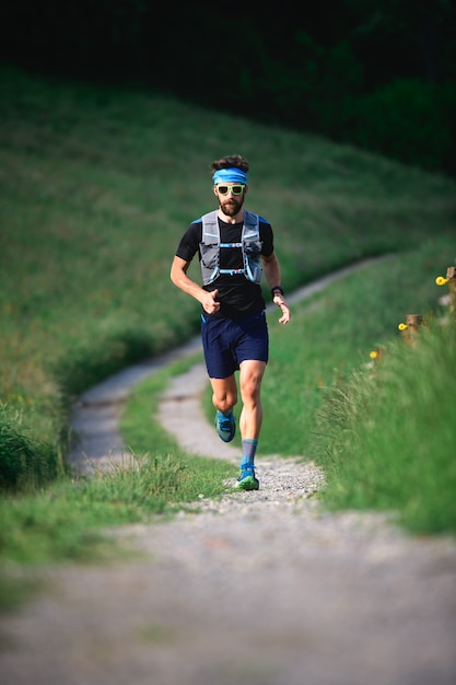 Uomo con atleta barba in esecuzione in montagna durante un allenamento