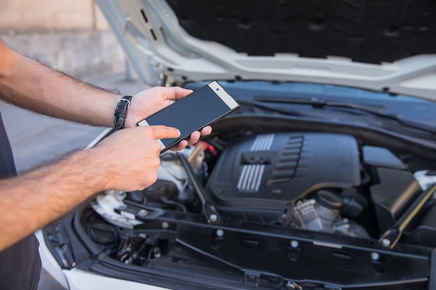 Uomo con auto rotta e smart phone