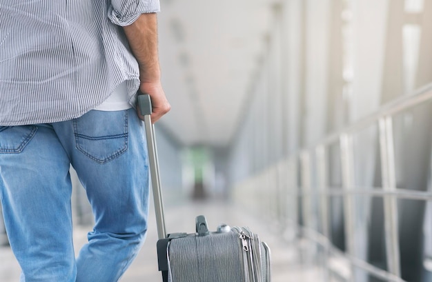 Uomo con bagagli in piedi nella passerella del terminal dell'aeroporto