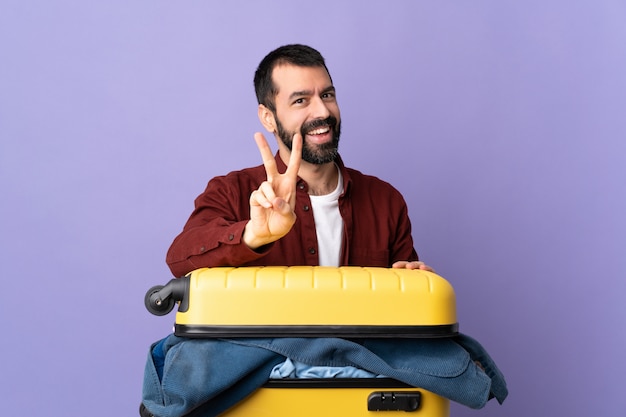 Uomo con bagaglio su sfondo viola isolato