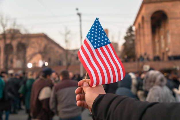 Uomo con bandiera americana in strada