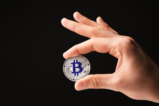 Uomo con bitcoin argento su sfondo nero