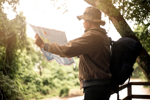 Uomo con borsa, cappuccio e in possesso di una mappa