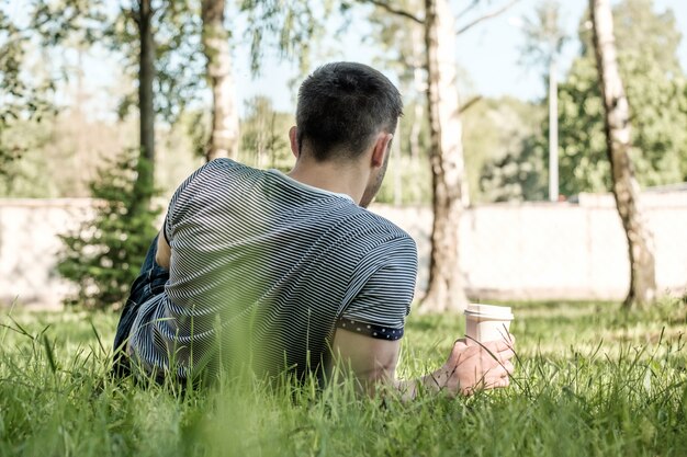 Uomo con caffè nel parco