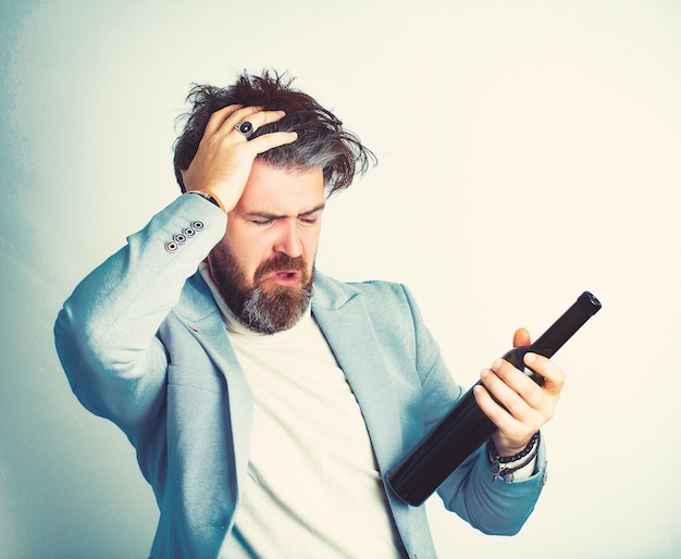 Uomo con capelli grigi e barba con alcol che indossa una giacca blu