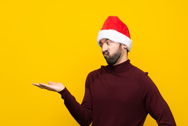 Uomo con cappello di natale che tiene con dubbi