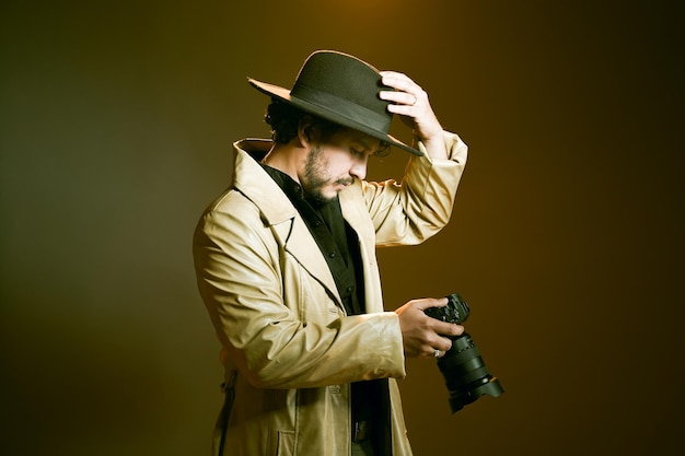 uomo con cappello in possesso di una macchina fotografica