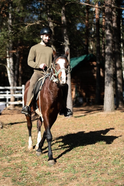 Uomo con casco a cavallo nella foresta