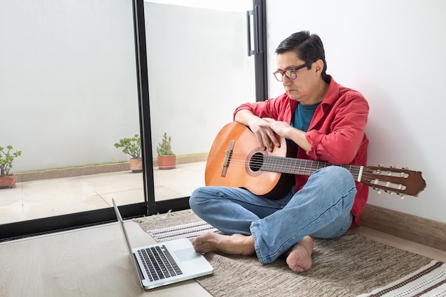 Uomo con chitarra classica in classe virtuale a casa