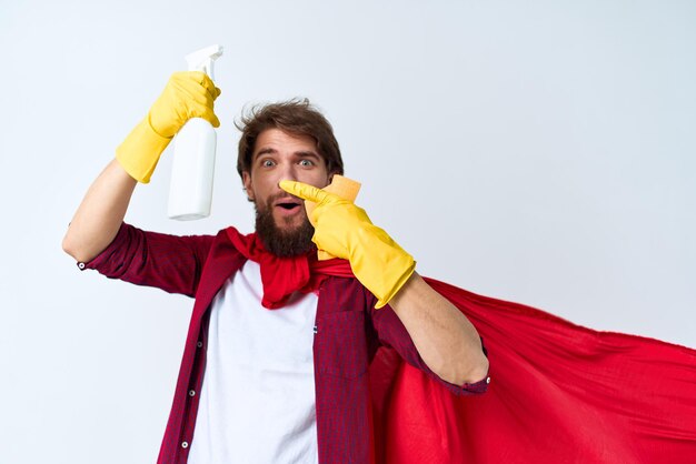 Uomo con detersivo nelle mani in guanti di gomma pulizia professionale dei lavori domestici
