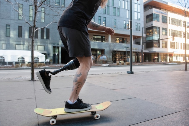 Uomo con disabilità alle gambe che fa skateboard in città