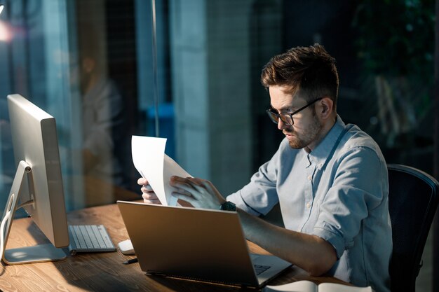 Uomo con documenti che lavorano in ufficio