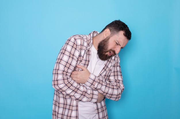 Uomo con dolore addominale problema di salute disagio diarrea sfondo blu