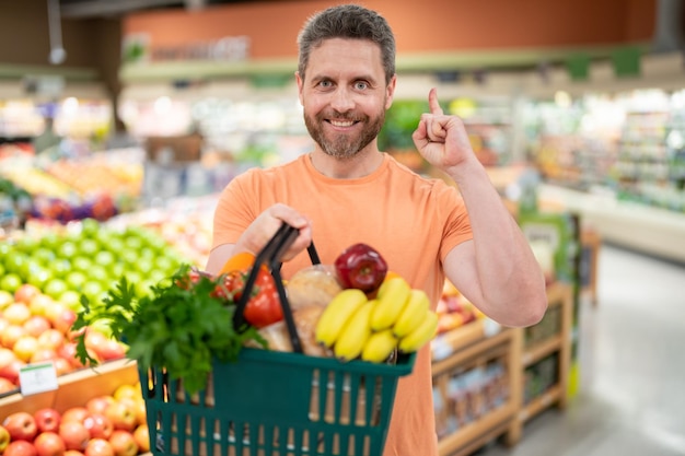 Uomo con frutta e verdura al supermercato Cibo sano per la salute degli uomini Uomo con il carrello pieno di verdure fresche Uomo al supermercato o al supermercato