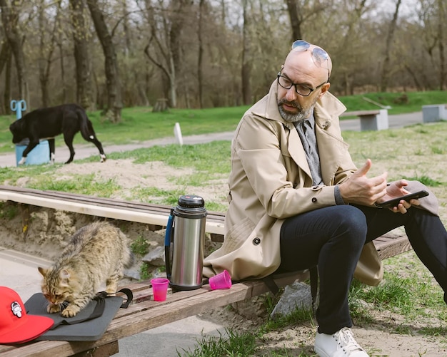 Uomo con gatto e cane nel parco