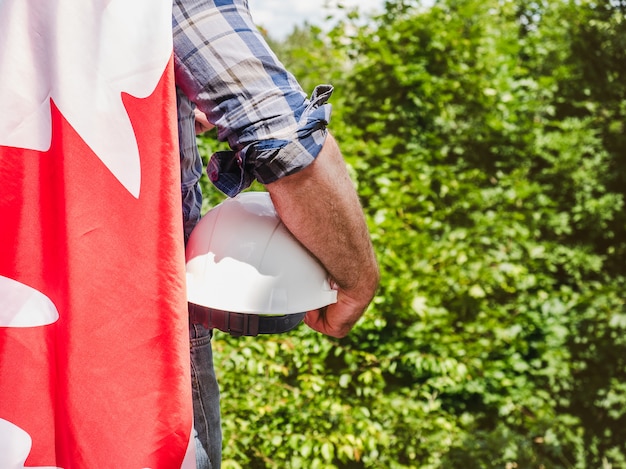 Uomo con il casco che tiene una bandiera canadese