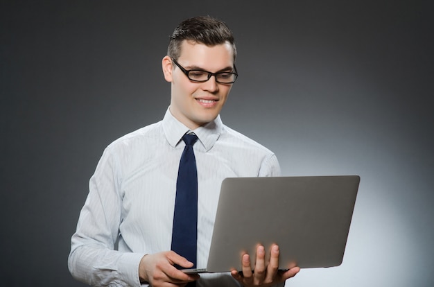 Uomo con il computer portatile nel concetto di affari