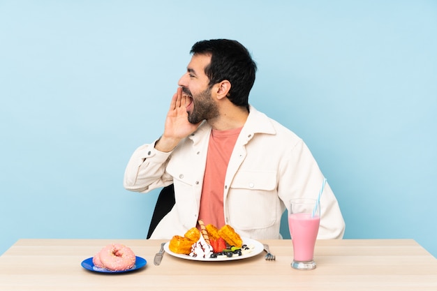 Uomo con la barba che beve un frappè