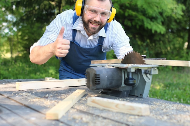 Uomo con la barba che lavora su una sega circolare