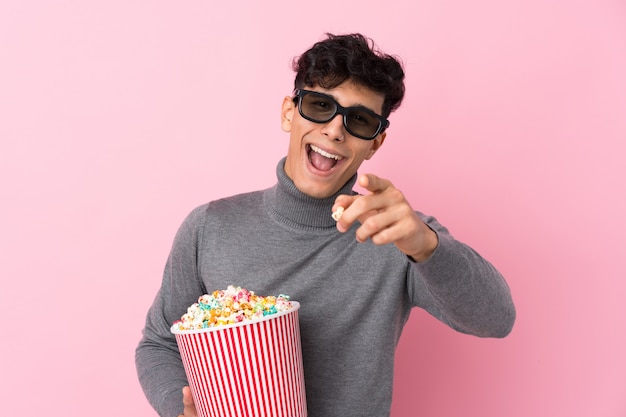 Uomo con la barba che tiene i popcorn sopra la parete isolata