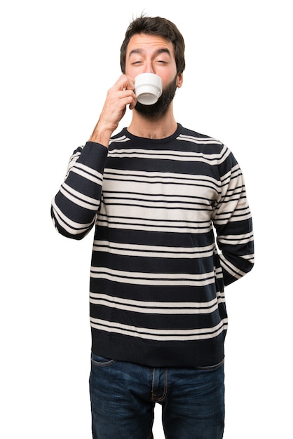 Uomo con la barba che tiene una tazza di caffè