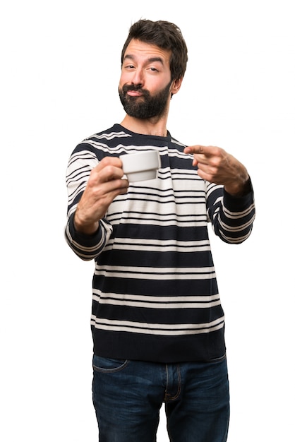 Uomo con la barba che tiene una tazza di caffè