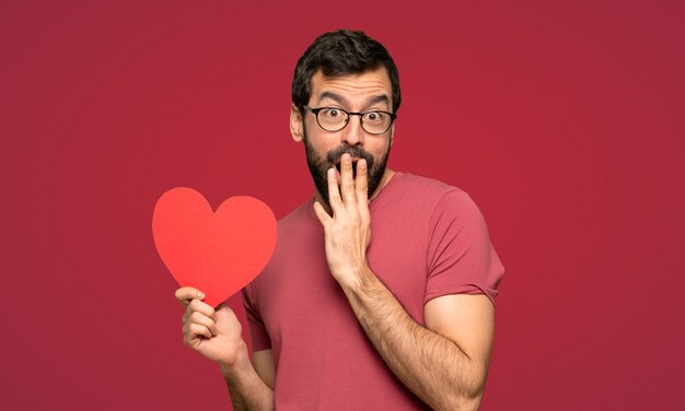 Uomo con la barba nel giorno di San Valentino su sfondo rosso