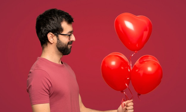 Uomo con la barba nel giorno di San Valentino su sfondo rosso