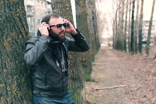 Uomo con la barba nel parco con le cuffie